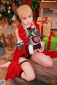 A woman in a red dress sitting on the floor next to a Christmas tree.