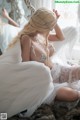 A woman in a wedding dress sitting on a fur rug.