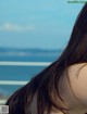 A woman with long brown hair looking out over the ocean.