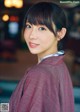 A woman in a red kimono is posing for a picture.