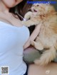 A woman holding a fluffy orange cat in her arms.