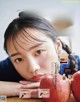 A woman sitting at a table with an apple in front of her.