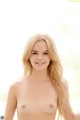 A nude woman with long blonde hair posing for the camera.