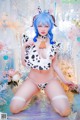 A woman in a bikini with blue hair and a cow costume.